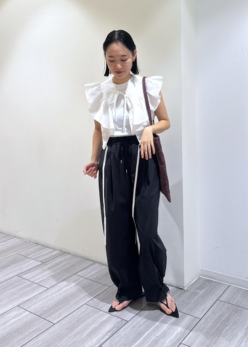 ブラック系のサンダル、ホワイト系のTシャツ/カットソー、ブラック系のその他パンツを着用したレディースの夏コーディネートの2枚目の写真
