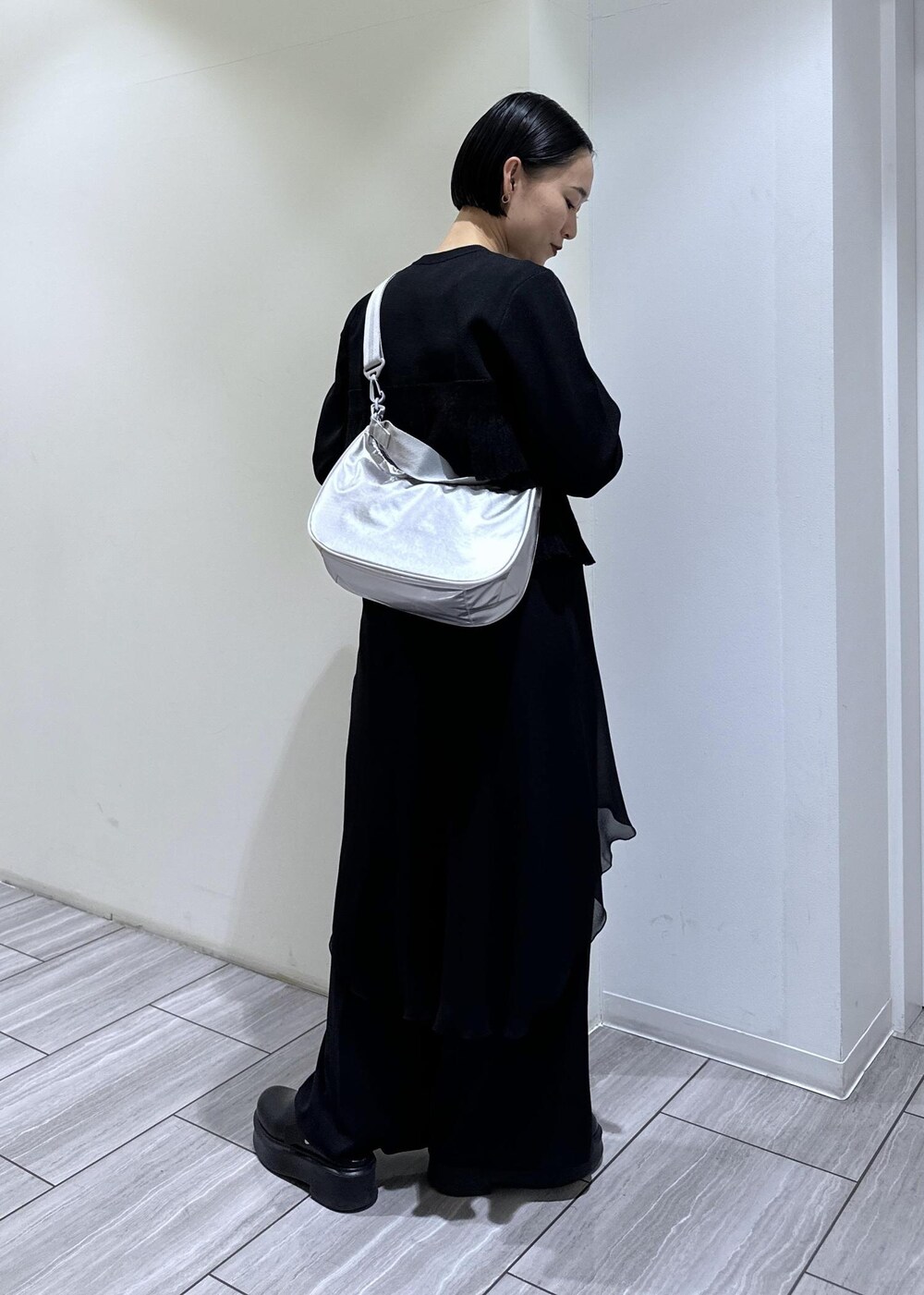 ブラック系のサンダル、ブラック系のカーディガン/ボレロ、シルバー系のショルダーバッグを着用したレディースの冬コーディネートの4枚目の写真