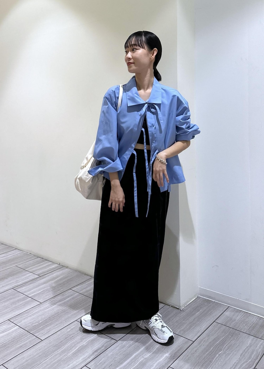 ブラック系のスカート、ブルー系のシャツ/ブラウス、ホワイト系のボディバッグ/ウエストポーチを着用したレディースの秋コーディネートの3枚目の写真