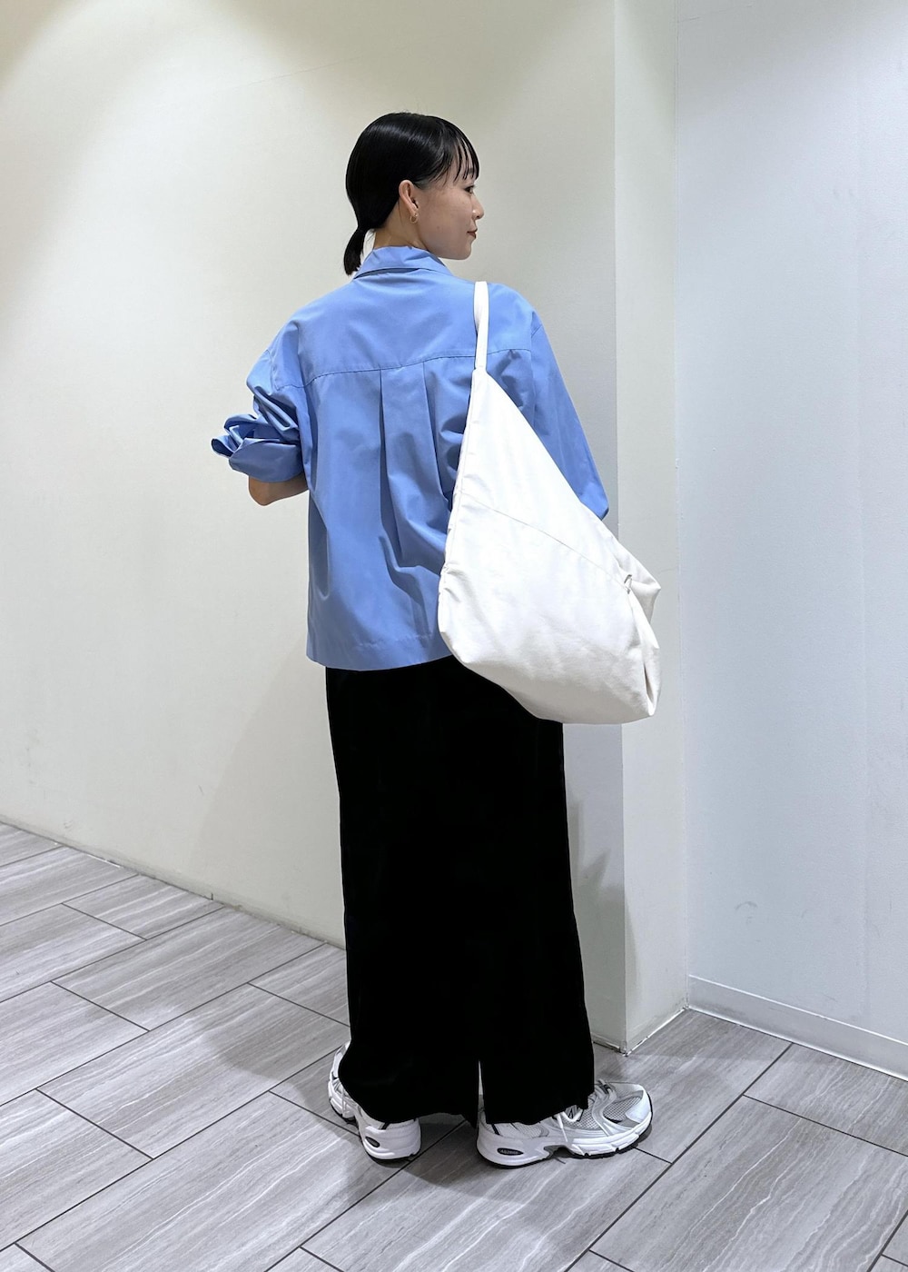 ブラック系のスカート、ブルー系のシャツ/ブラウス、ホワイト系のボディバッグ/ウエストポーチを着用したレディースの秋コーディネートの5枚目の写真