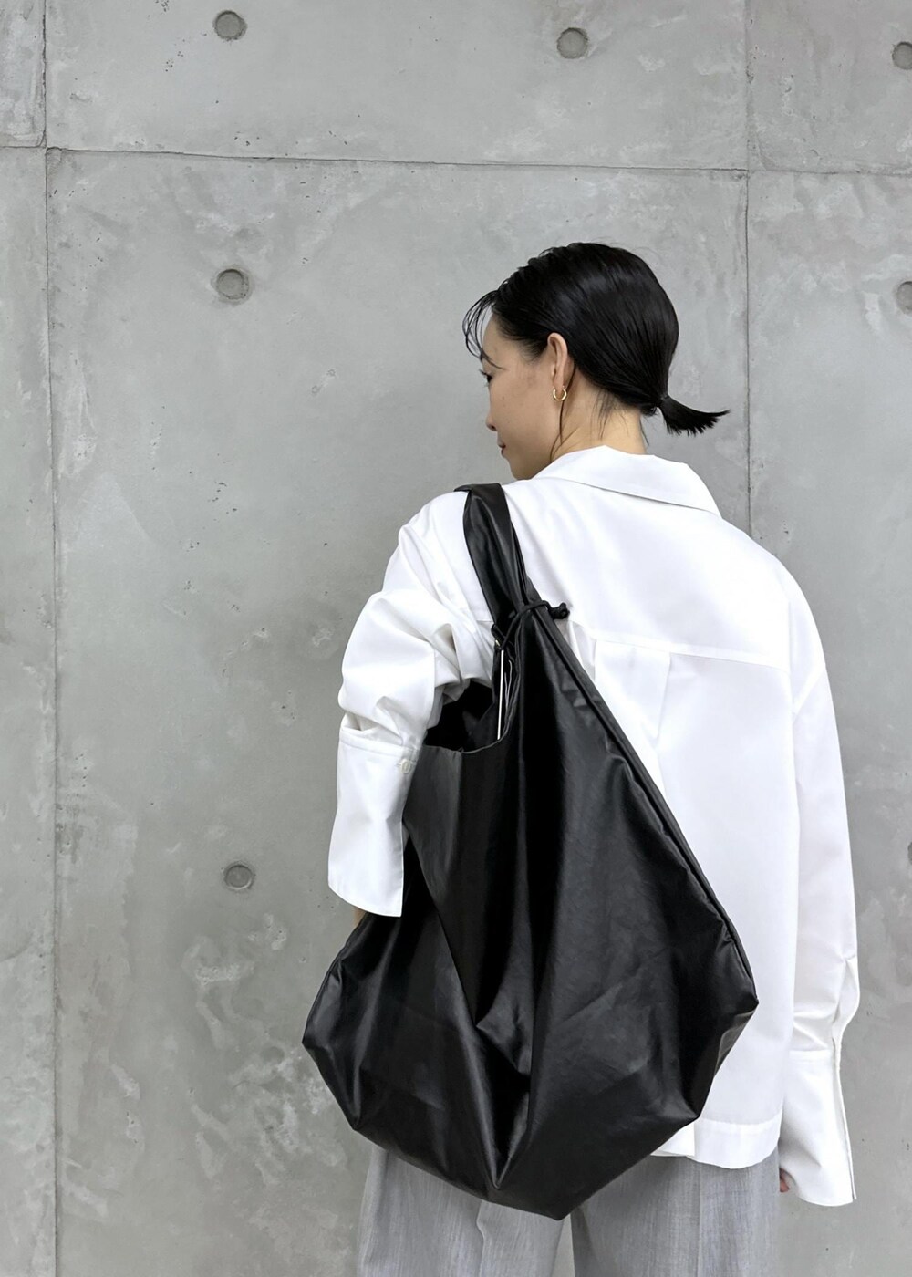 ゴールド系のパンプス、ホワイト系のシャツ/ブラウス、グレー系のスラックスを着用したレディースの秋コーディネートの4枚目の写真