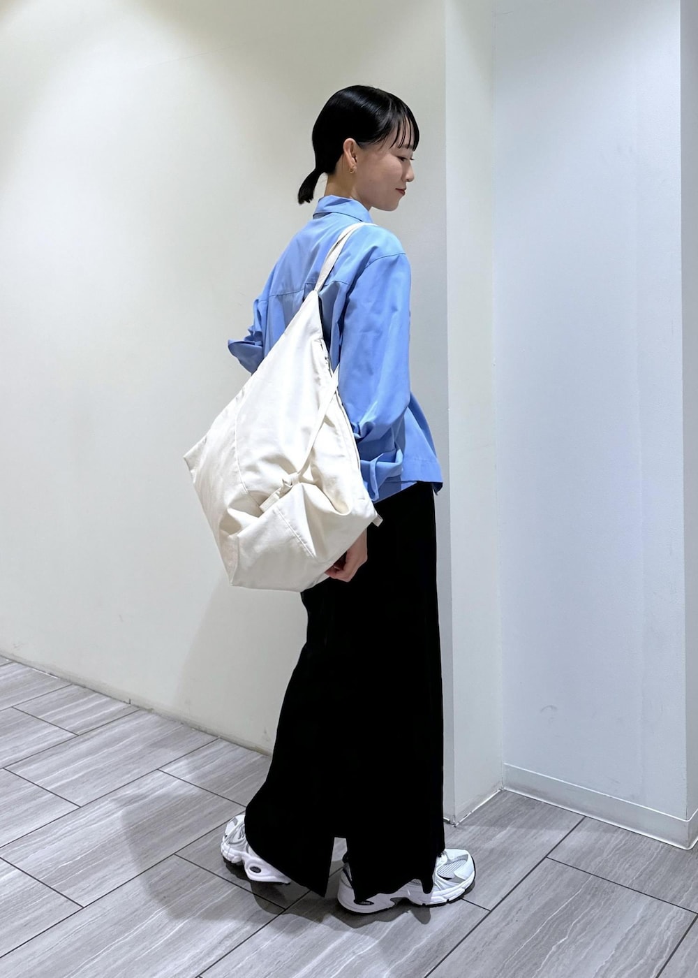 ブラック系のスカート、ブルー系のシャツ/ブラウス、ホワイト系のボディバッグ/ウエストポーチを着用したレディースの秋コーディネートの6枚目の写真