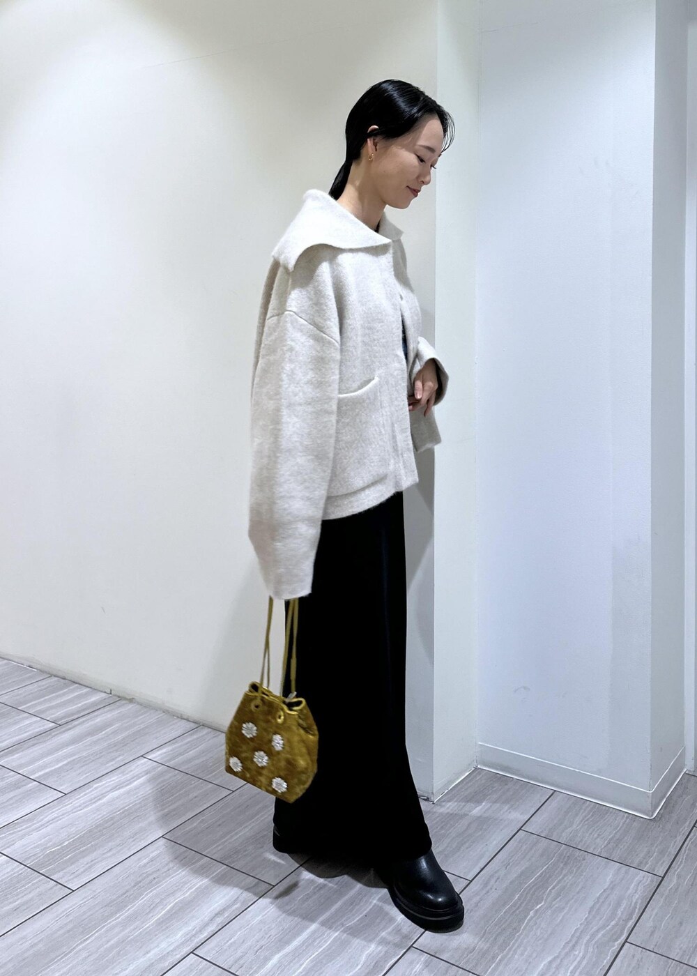 ブラック系のブーツ、ブラック系のワンピース、ホワイト系のカーディガン/ボレロを着用したレディースの秋コーディネートの5枚目の写真