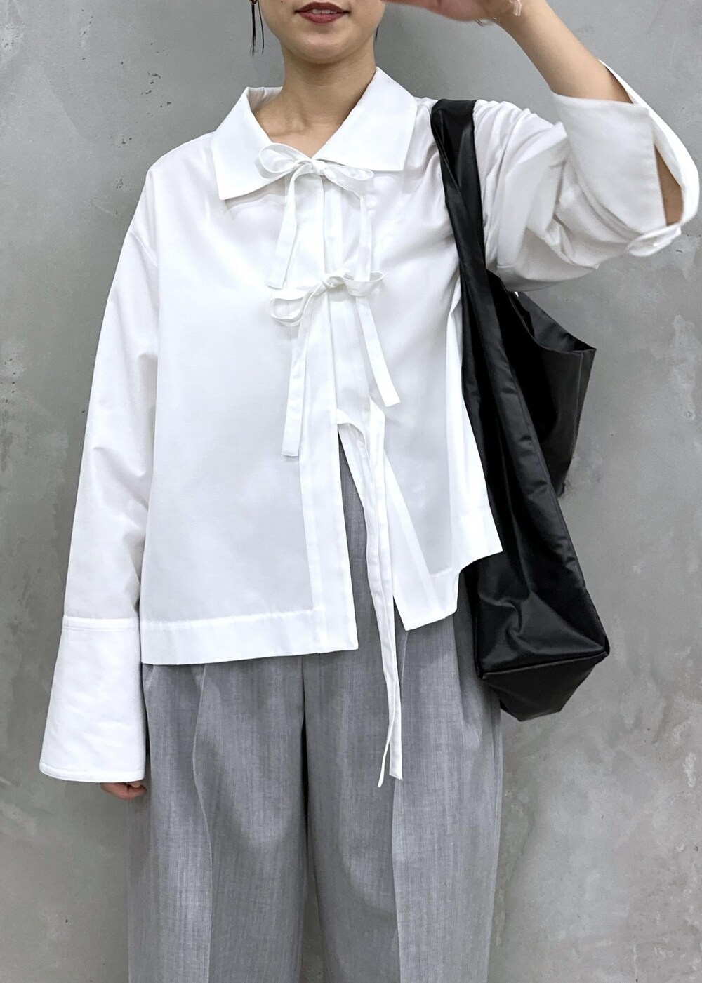 ゴールド系のパンプス、ホワイト系のシャツ/ブラウス、グレー系のスラックスを着用したレディースの秋コーディネートの3枚目の写真