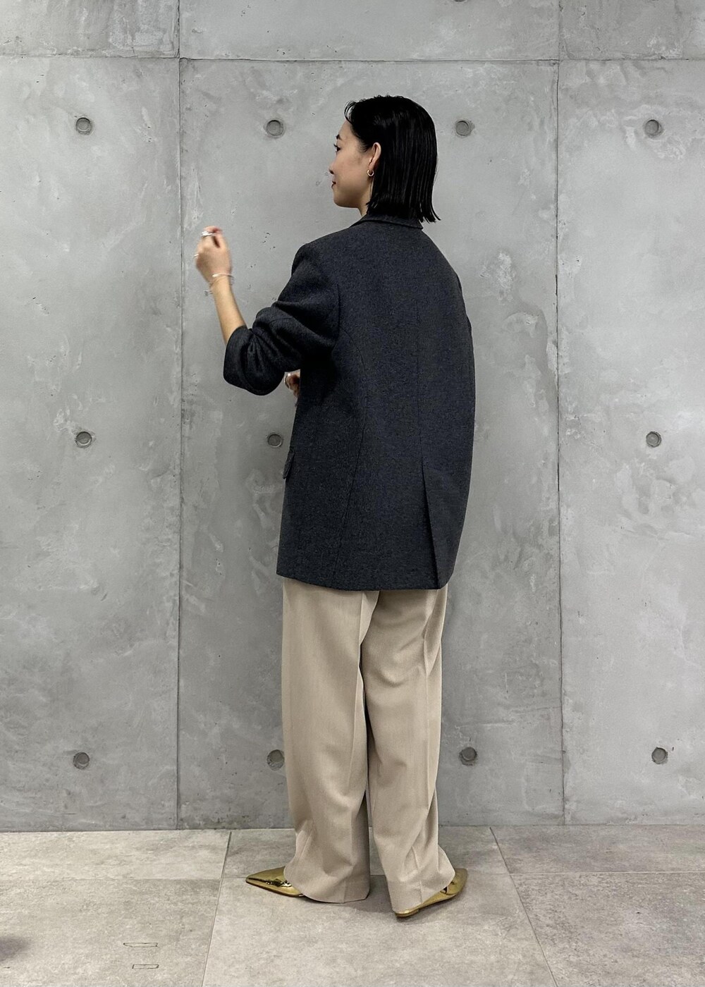 ゴールド系のパンプス、ベージュ系のスラックス、ブラック系のその他アウターを着用したレディースの秋コーディネートの5枚目の写真