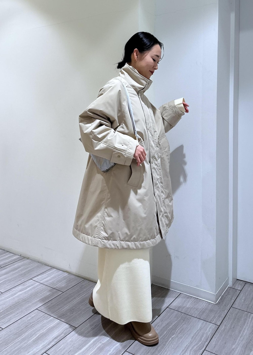ベージュ系のブーツ、ホワイト系のワンピース、ベージュ系のその他アウターを着用したレディースの冬コーディネートの7枚目の写真