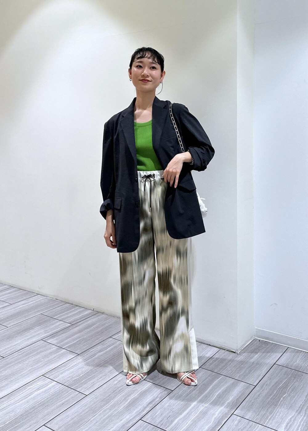 ベージュ系のその他パンツ、ホワイト系のショルダーバッグ、ホワイト系のサンダルを着用したレディースの春コーディネートの2枚目の写真