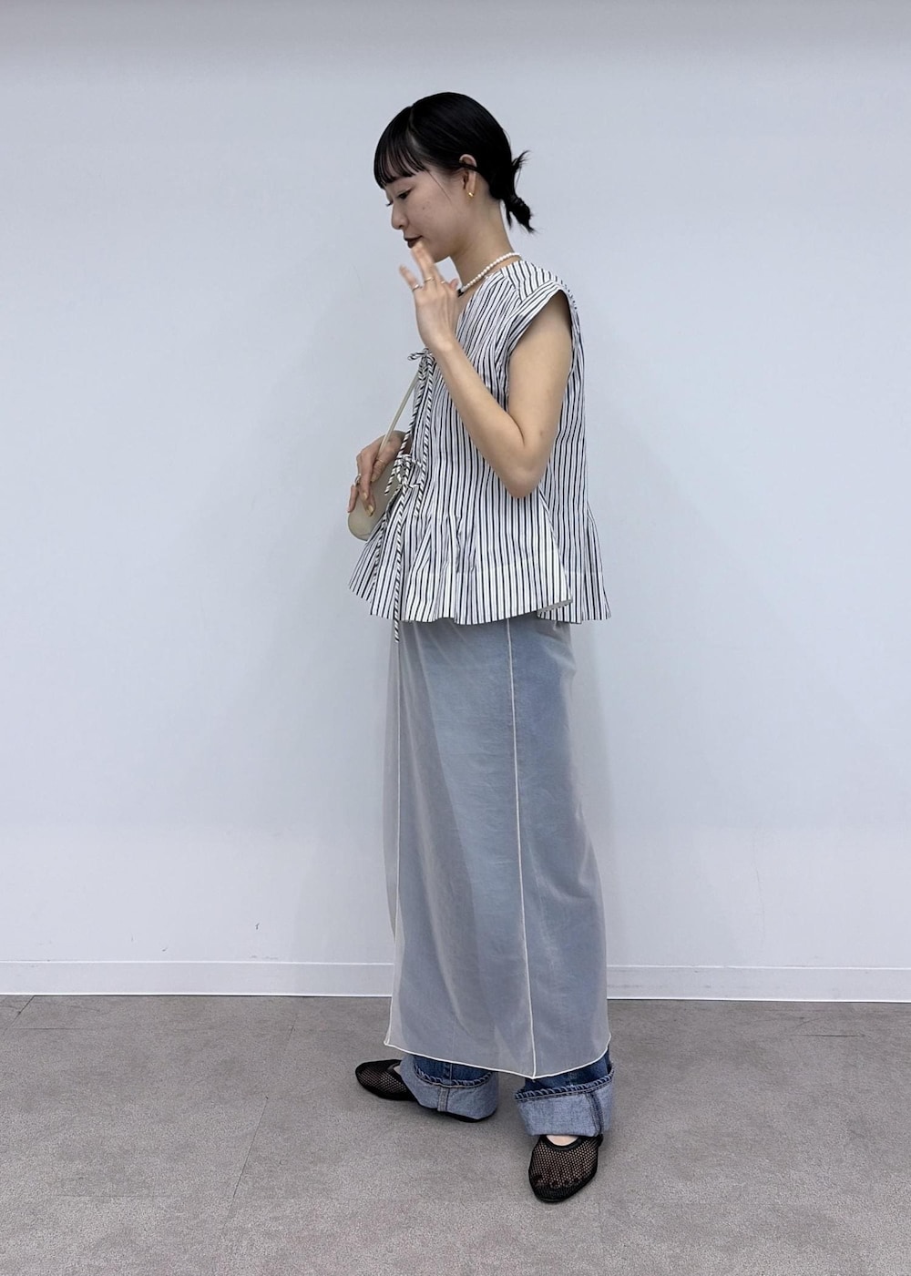 ブラック系のパンプス、ブルー系のシャツ/ブラウス、ホワイト系のワンピースを着用したレディースの夏コーディネートの3枚目の写真