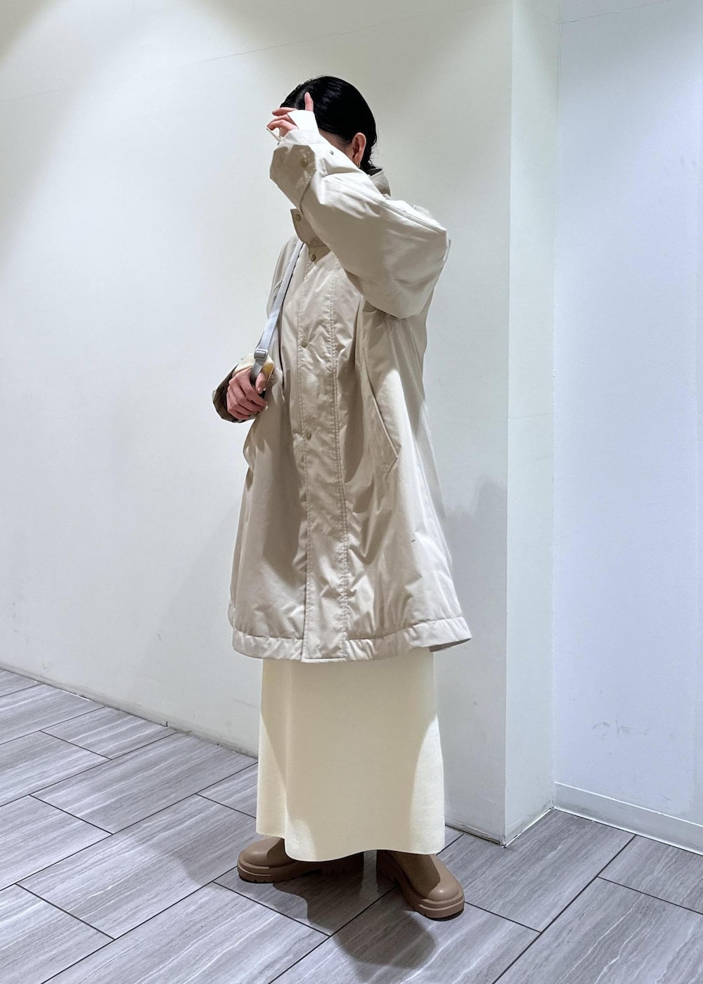 ベージュ系のブーツ、ホワイト系のワンピース、ベージュ系のその他アウターを着用したレディースの冬コーディネートの3枚目の写真