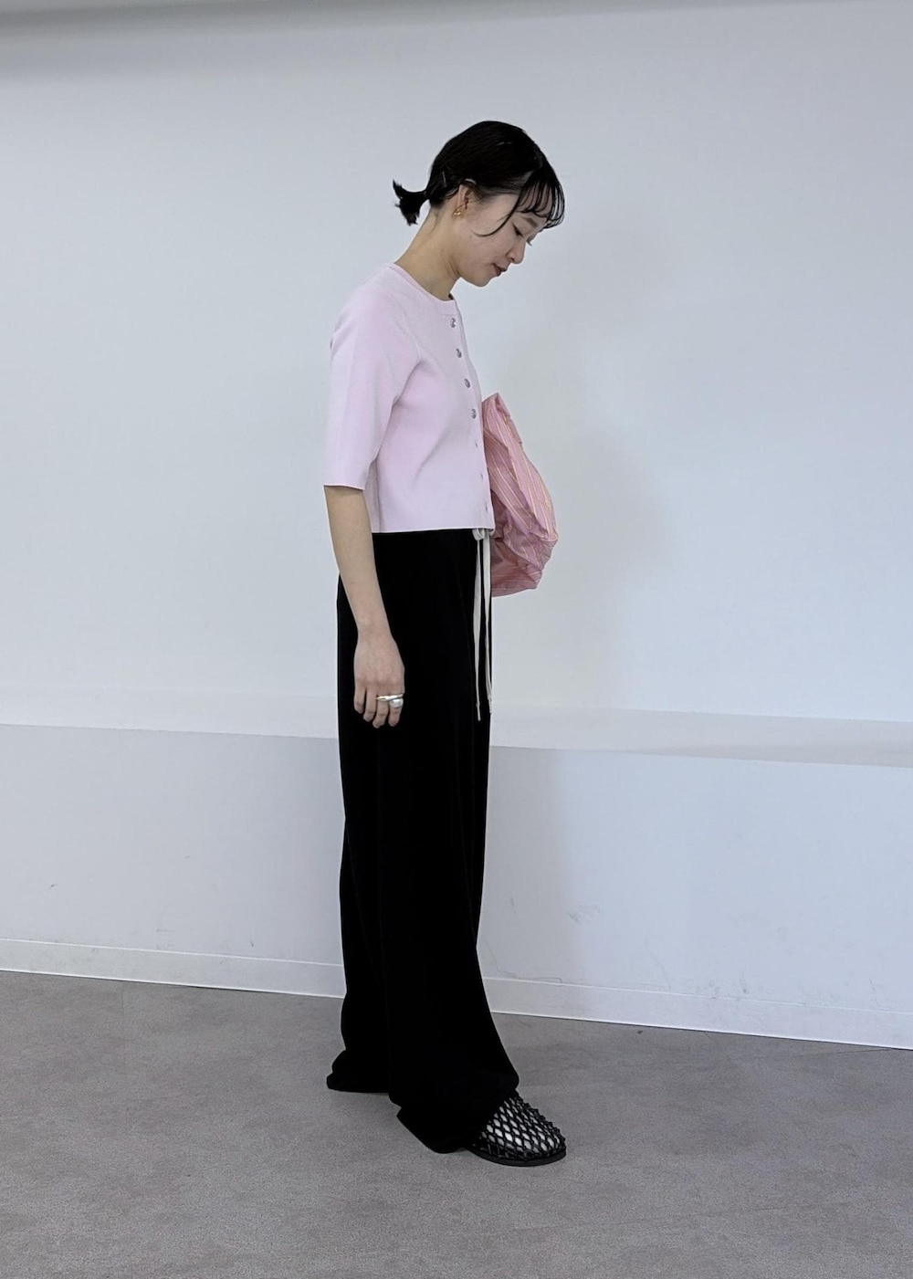 ブラック系のサンダル、ピンク系のカーディガン/ボレロ、ブラック系のその他パンツを着用したレディースの春コーディネートの5枚目の写真