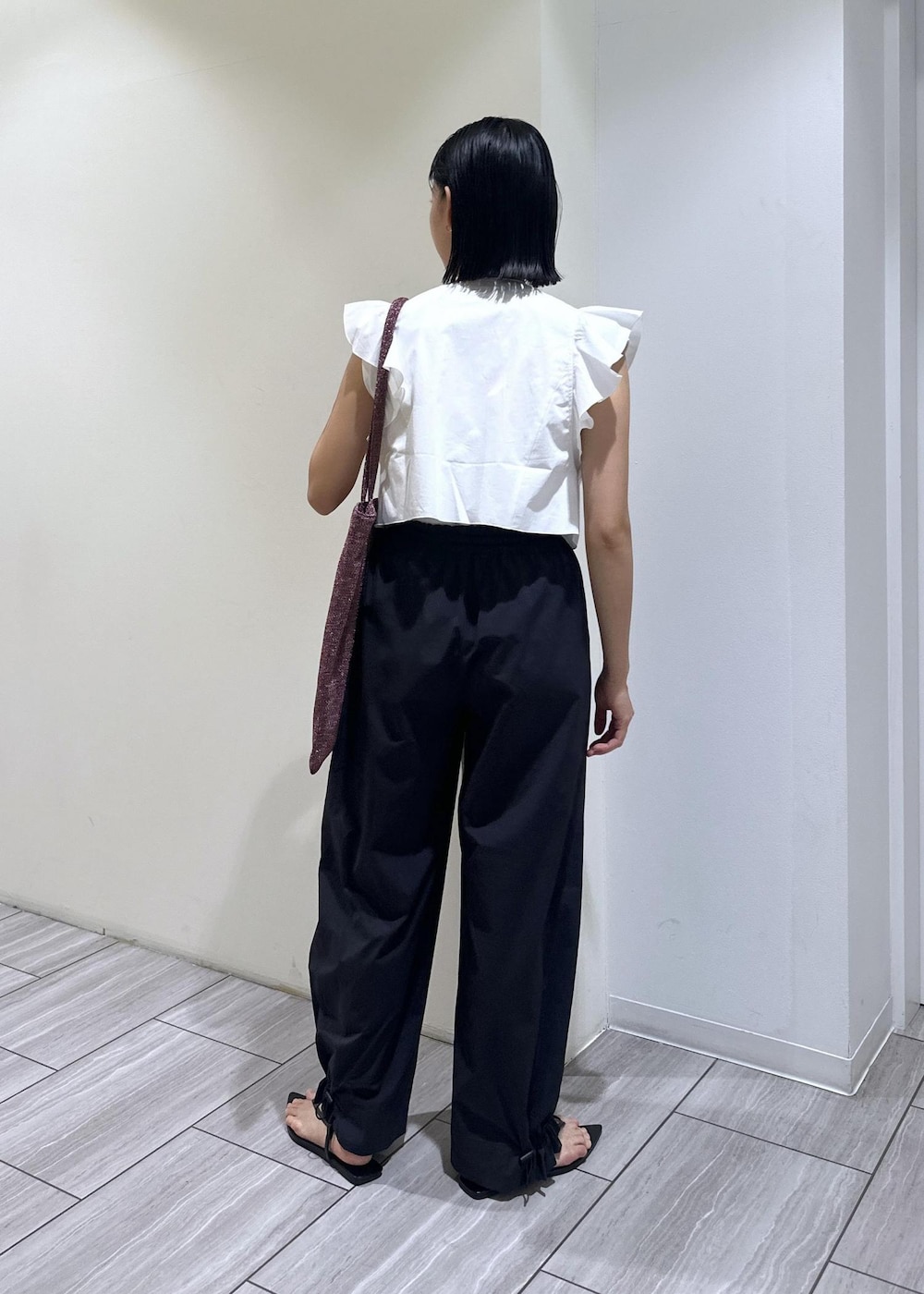 ブラック系のサンダル、ホワイト系のTシャツ/カットソー、ブラック系のその他パンツを着用したレディースの夏コーディネートの5枚目の写真