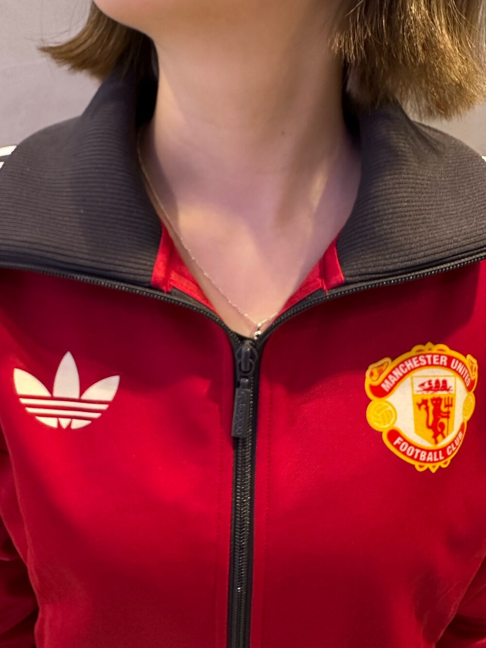 レッド系のその他アウター、ブルー系のスニーカーを着用したレディースの冬コーディネートの2枚目の写真