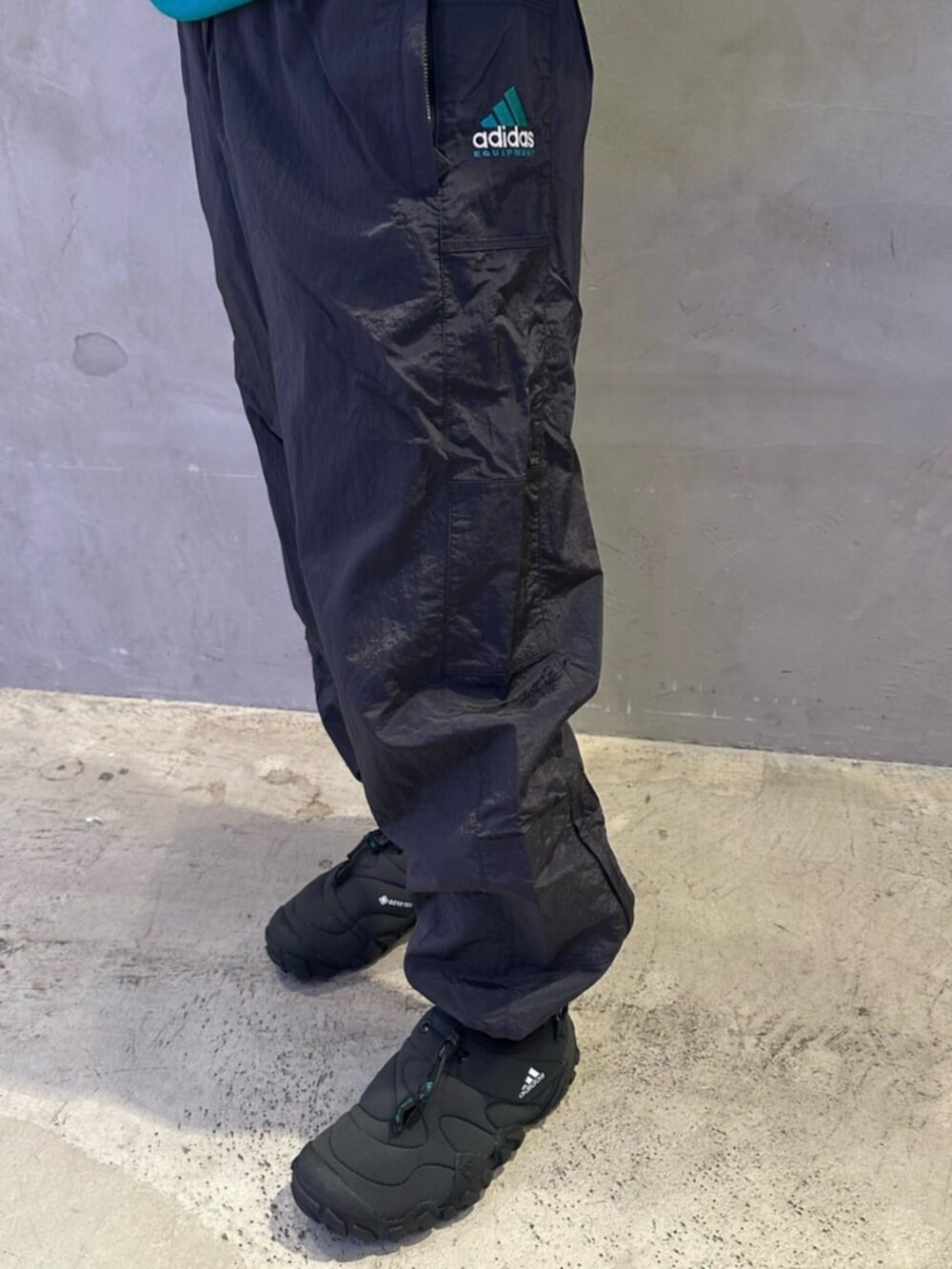 ブラック系のシューズ、グリーン系のトップス、ブラック系のパンツを着用したレディースの春コーディネートの2枚目の写真