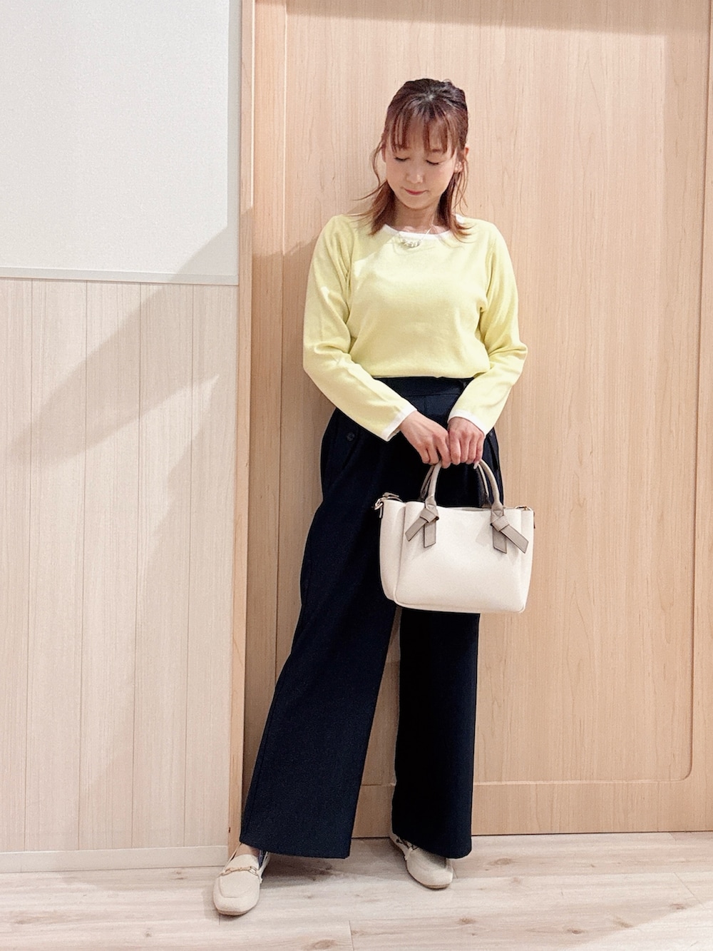 イエロー系のニット/セーター、イエロー系のカーディガン/ボレロ、ベージュ系のトートバッグを着用したレディースの春コーディネートの4枚目の写真