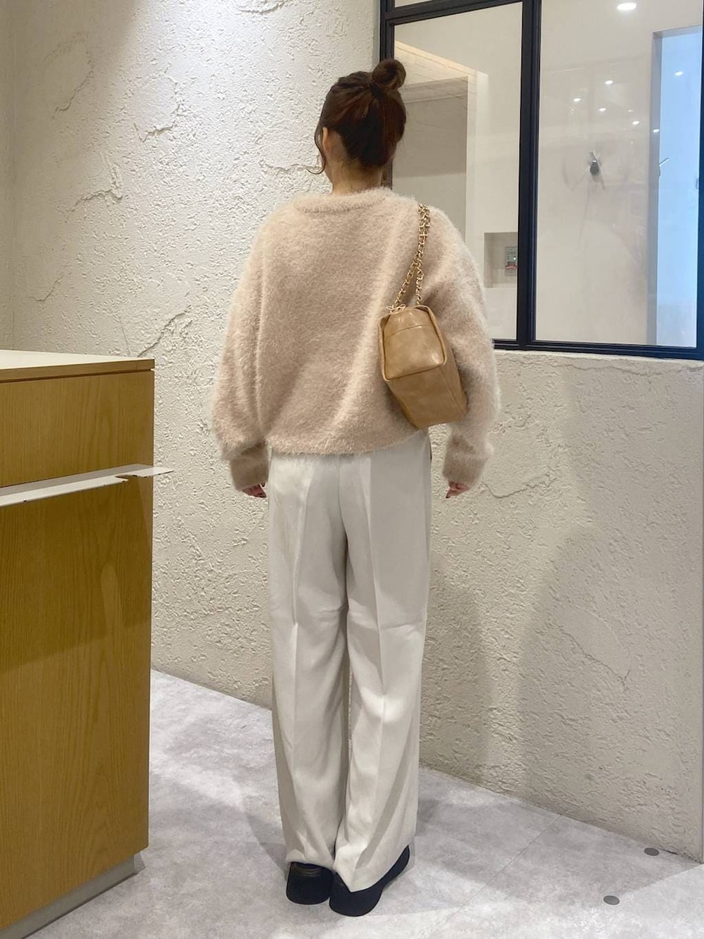 ホワイト系のスラックス、ブラウン系のサンダル、ホワイト系のニット/セーターを着用したレディースの秋コーディネートの3枚目の写真