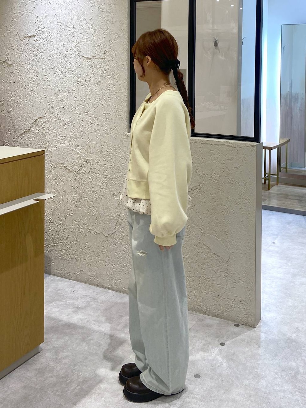 ブルー系のデニムパンツ、ブラウン系のサンダル、イエロー系のスウェットを着用したレディースの冬コーディネートの2枚目の写真