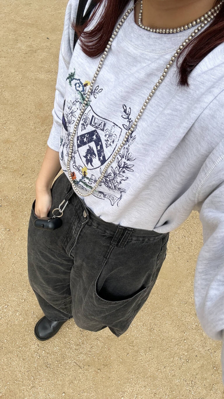 ブラック系のデニムパンツ、グレー系のスウェット、シルバー系のネックレスを着用したレディースの秋コーディネートの2枚目の写真