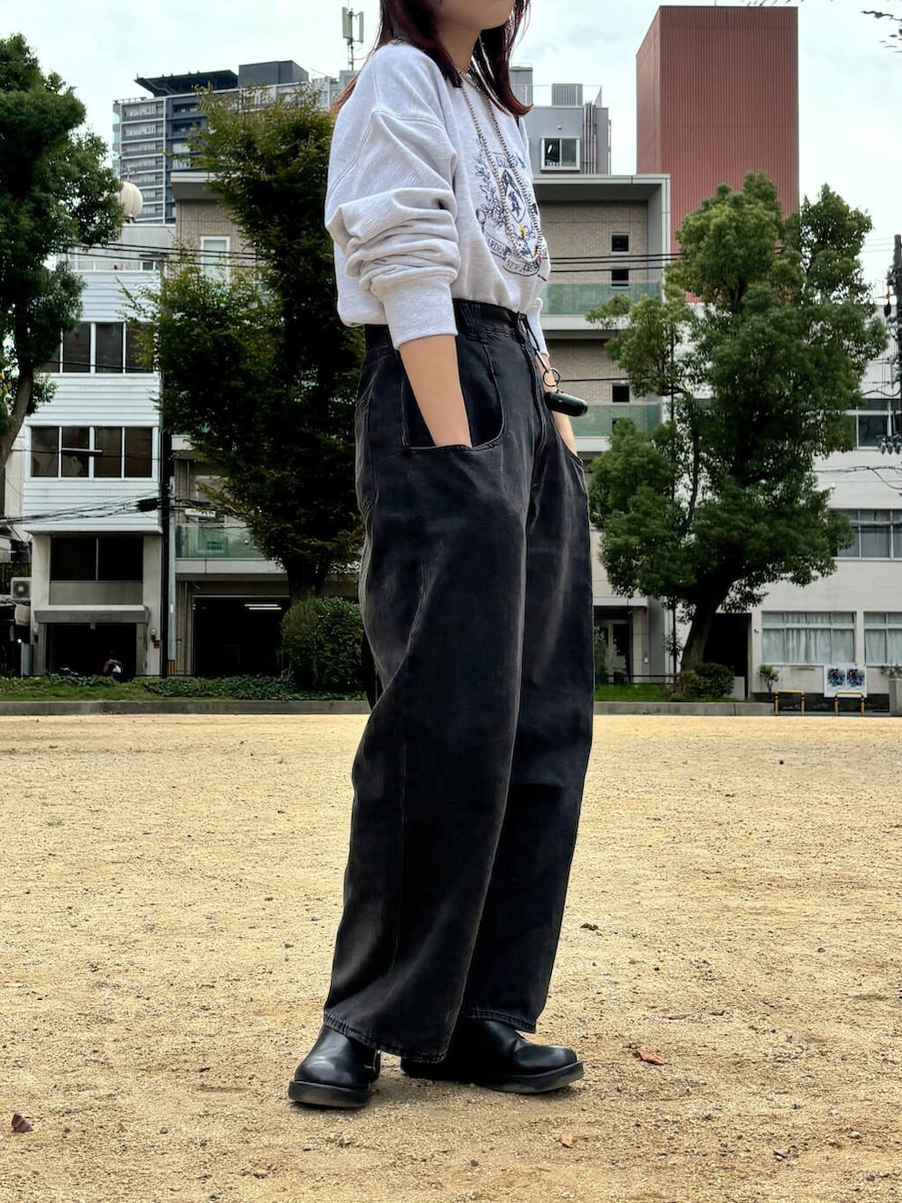 ブラック系のデニムパンツ、グレー系のスウェット、シルバー系のネックレスを着用したレディースの秋コーディネートの5枚目の写真