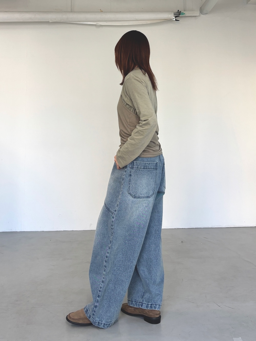 グリーン系のTシャツ/カットソー、ベージュ系のローファー、ブルー系のデニムパンツを着用したレディースの春コーディネートの2枚目の写真