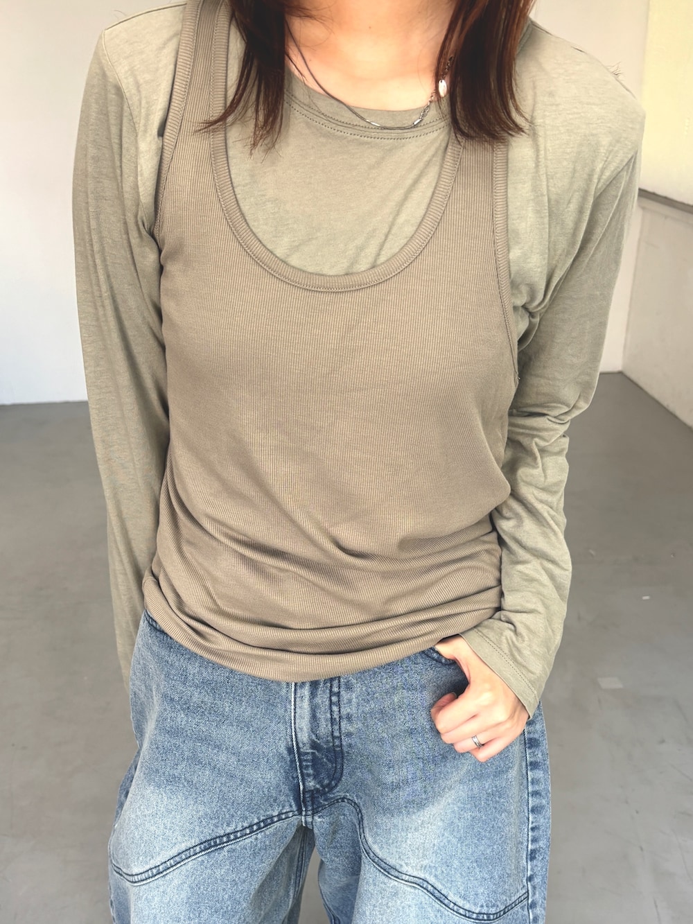 グリーン系のTシャツ/カットソー、ベージュ系のローファー、ブルー系のデニムパンツを着用したレディースの春コーディネートの4枚目の写真