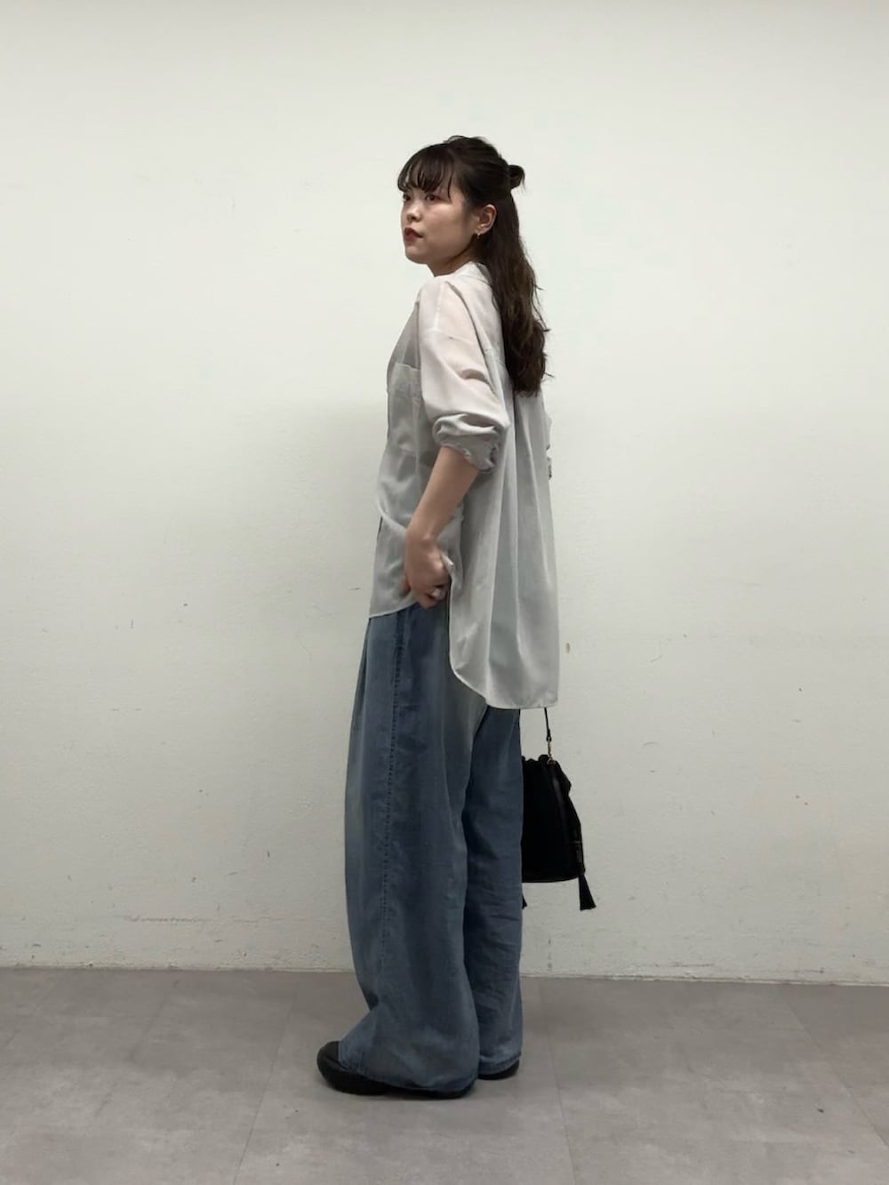 ブラック系のトートバッグ、ブルー系のその他パンツ、グレー系のシャツ/ブラウスを着用したレディースの春コーディネートの2枚目の写真