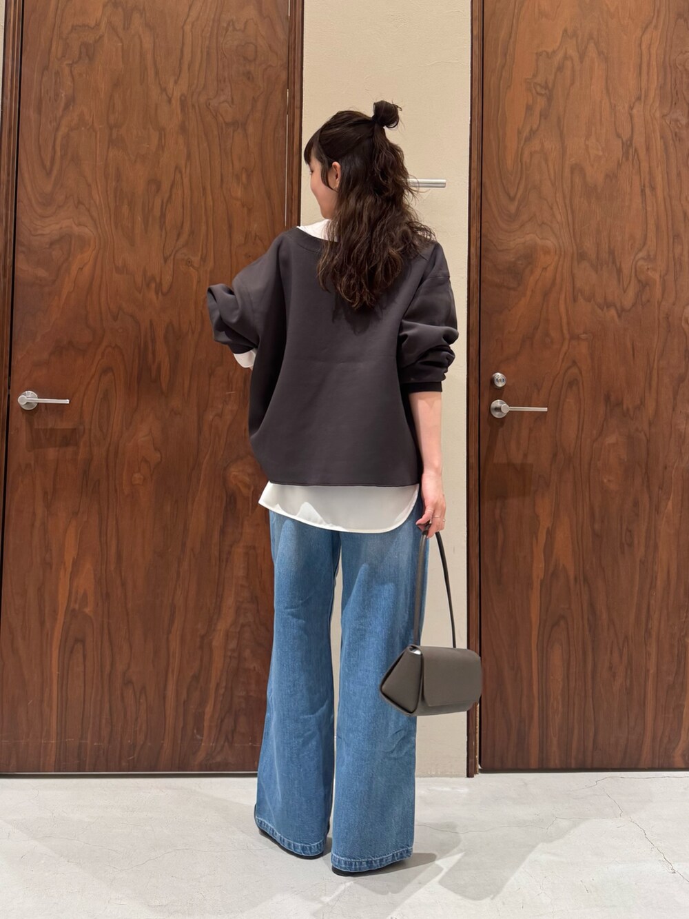 ホワイト系のシャツ/ブラウス、ブルー系のデニムパンツ、ブラック系のブーツを着用したレディースの冬コーディネートの5枚目の写真