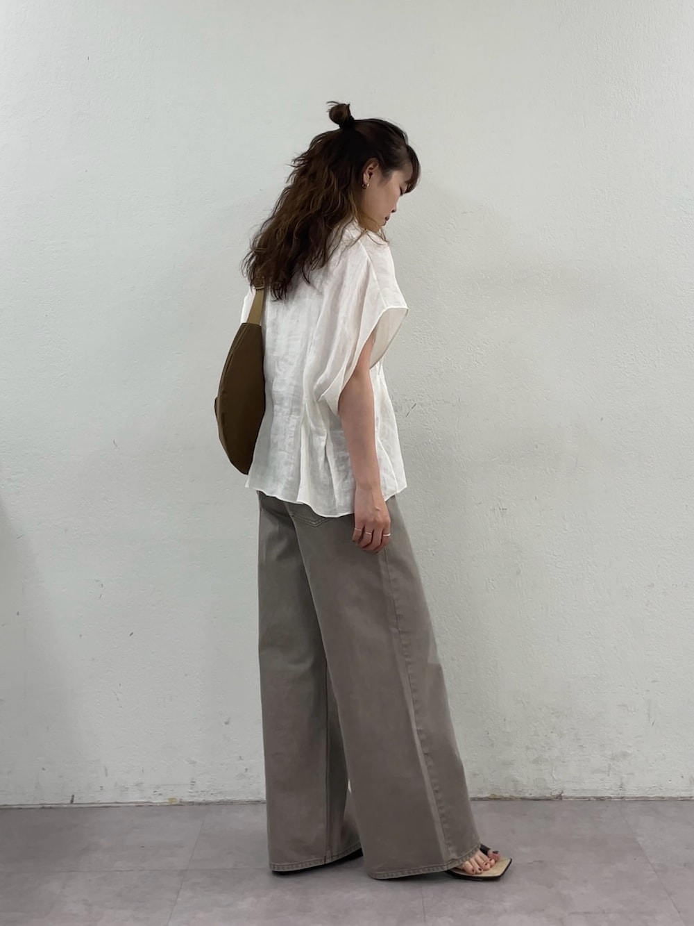 ホワイト系のシャツ/ブラウス、ブラウン系のデニムパンツ、イエロー系のショルダーバッグを着用したレディースの春コーディネートの7枚目の写真