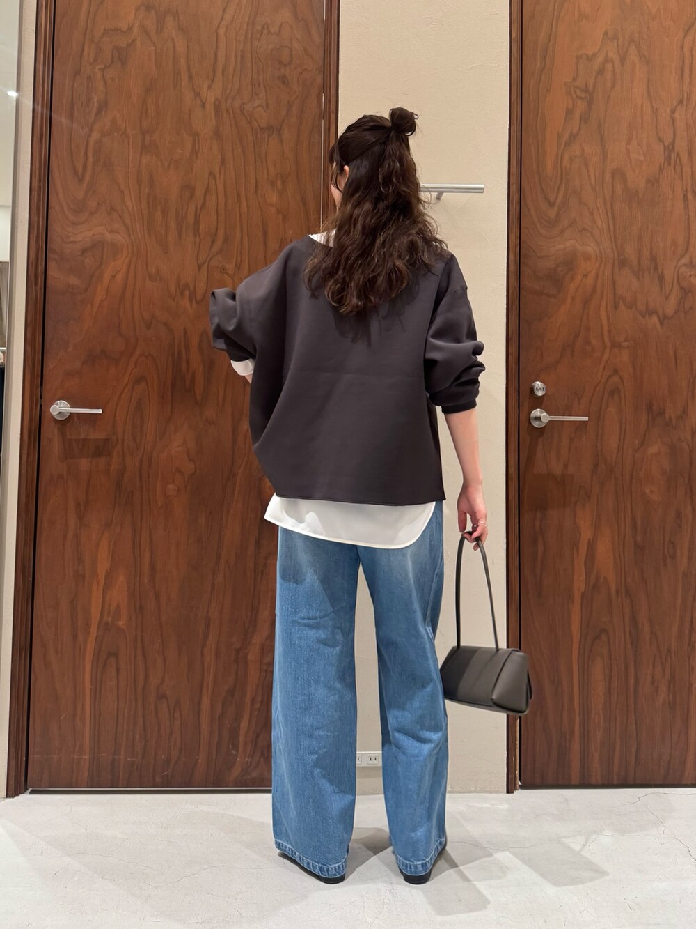 ホワイト系のシャツ/ブラウス、ブルー系のデニムパンツ、ブラック系のブーツを着用したレディースの冬コーディネートの3枚目の写真