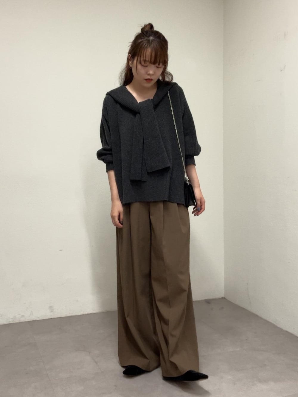グレー系のニット/セーター、ブラウン系のその他パンツ、ブラック系のパンプスを着用したレディースの秋コーディネートの4枚目の写真