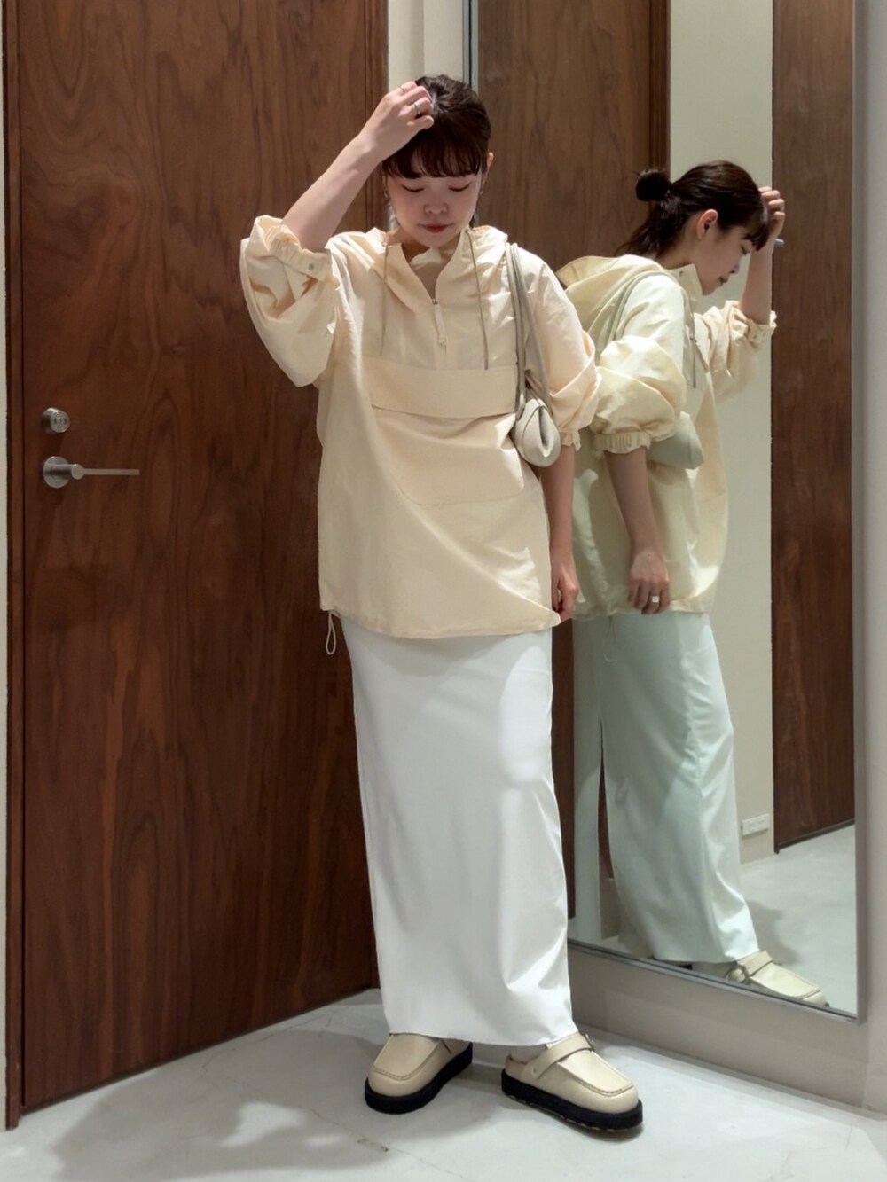 ホワイト系のベスト、ホワイト系のスカート、ホワイト系のその他シューズを着用したレディースの春コーディネートの3枚目の写真