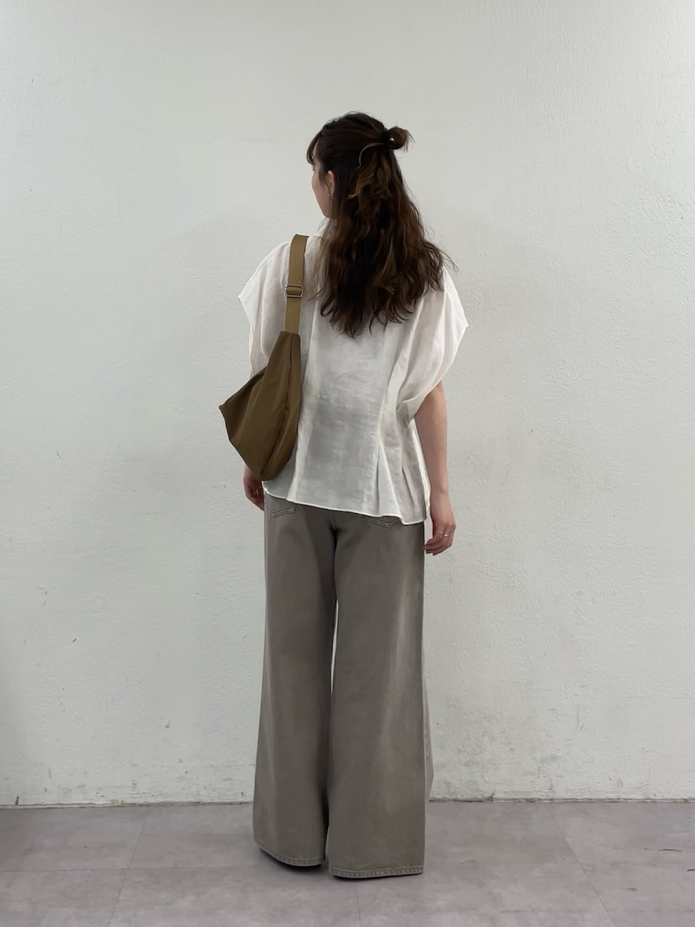 ホワイト系のシャツ/ブラウス、ブラウン系のデニムパンツ、イエロー系のショルダーバッグを着用したレディースの春コーディネートの3枚目の写真