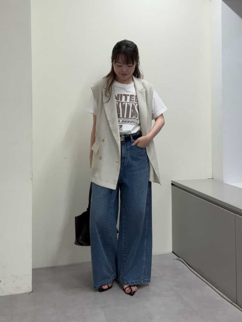 ベージュ系のベスト、ホワイト系のTシャツ/カットソー、ブラック系のサンダルを着用したレディースの春コーディネートの6枚目の写真