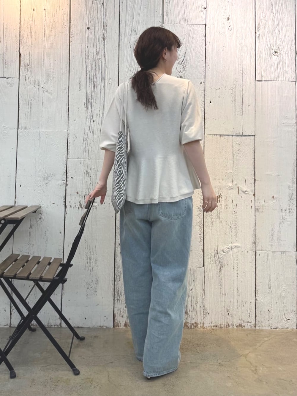 ブルー系のデニムパンツ、ブラウン系のサンダル、グレー系のニット/セーターを着用したレディースの春コーディネートの2枚目の写真