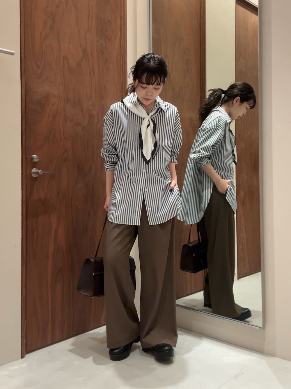 ブルー系のシャツ/ブラウス、ブラック系のその他パンツ、ブラック系のブーツを着用したレディースの冬コーディネートの3枚目の写真