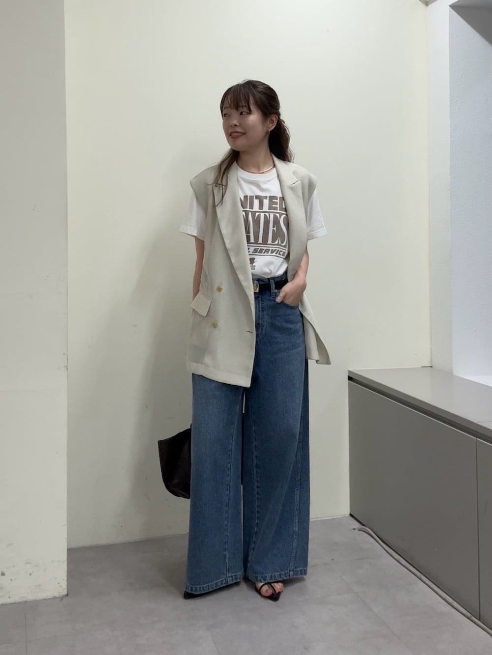 ベージュ系のベスト、ホワイト系のTシャツ/カットソー、ブラック系のサンダルを着用したレディースの春コーディネートの7枚目の写真