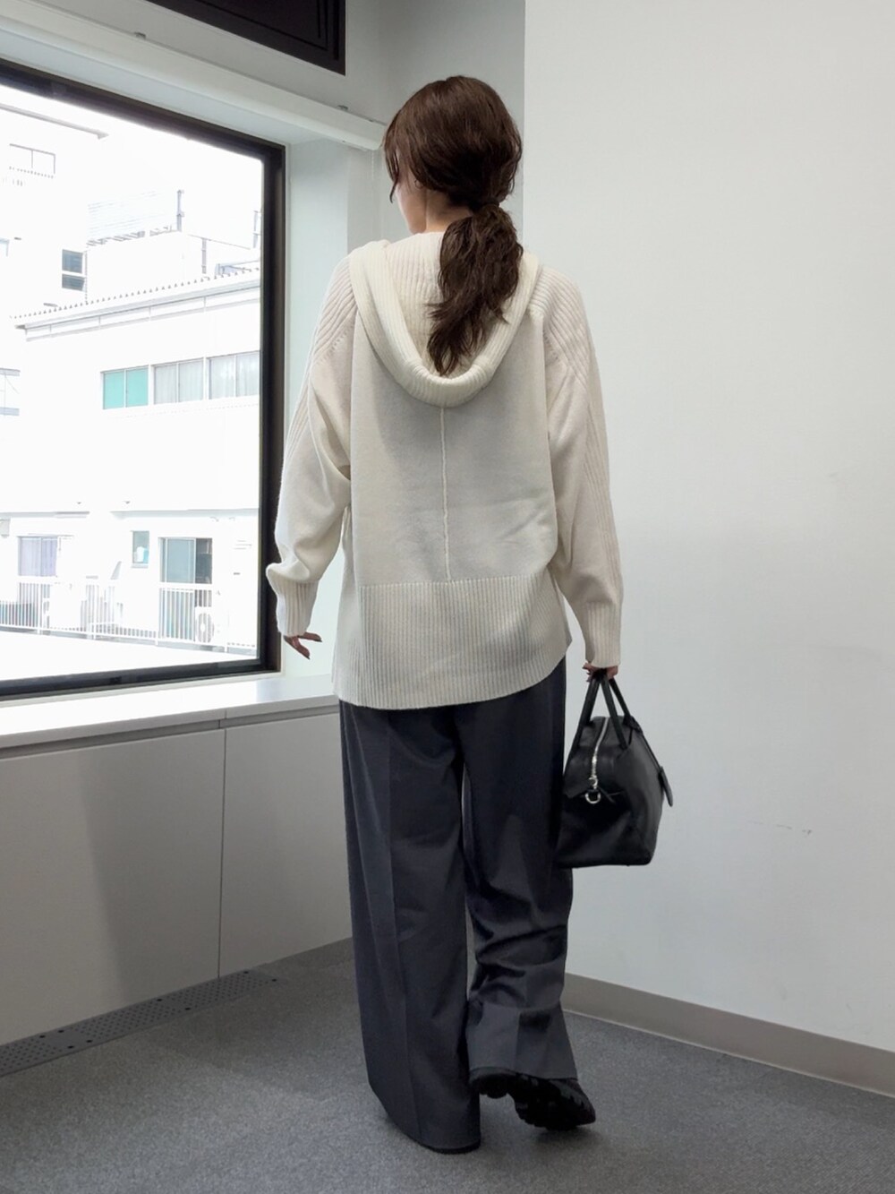 ホワイト系のニット/セーター、グレー系のその他パンツ、ブラック系のブーツを着用したレディースの秋コーディネートの3枚目の写真