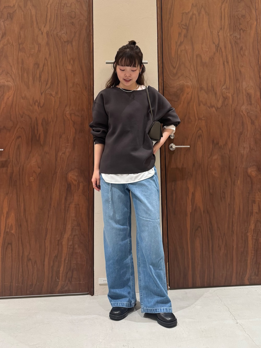 ホワイト系のシャツ/ブラウス、ブルー系のデニムパンツ、ブラック系のブーツを着用したレディースの冬コーディネートの4枚目の写真