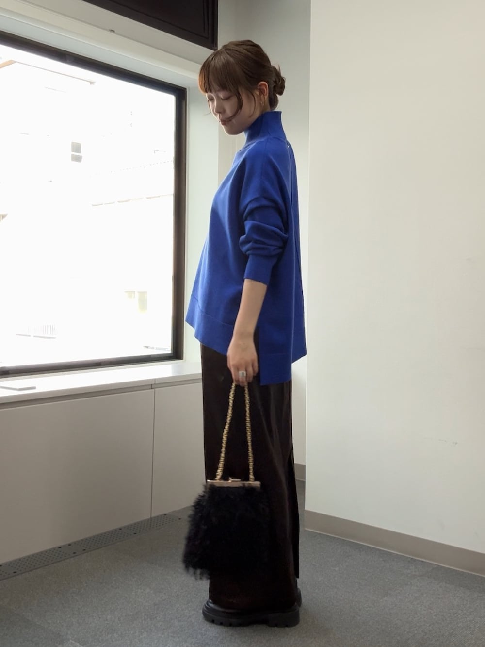 ブルー系のニット/セーター、ブラック系のショルダーバッグ、ブラウン系のスカートを着用したレディースの秋コーディネートの6枚目の写真