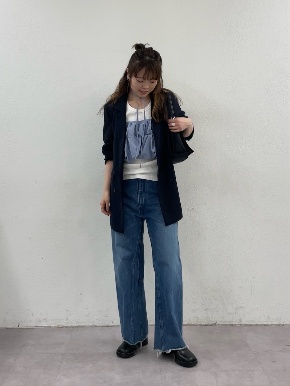 ブルー系のデニムパンツ、ブラック系のショルダーバッグ、ブルー系のテーラードジャケットを着用したレディースの春コーディネートの4枚目の写真