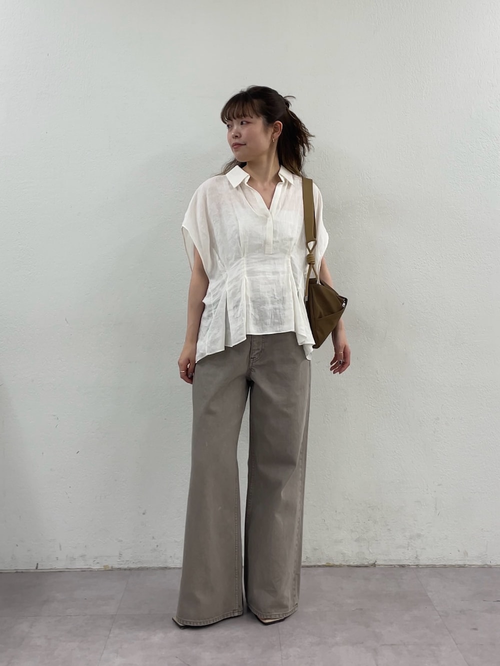 ホワイト系のシャツ/ブラウス、ブラウン系のデニムパンツ、イエロー系のショルダーバッグを着用したレディースの春コーディネートの8枚目の写真