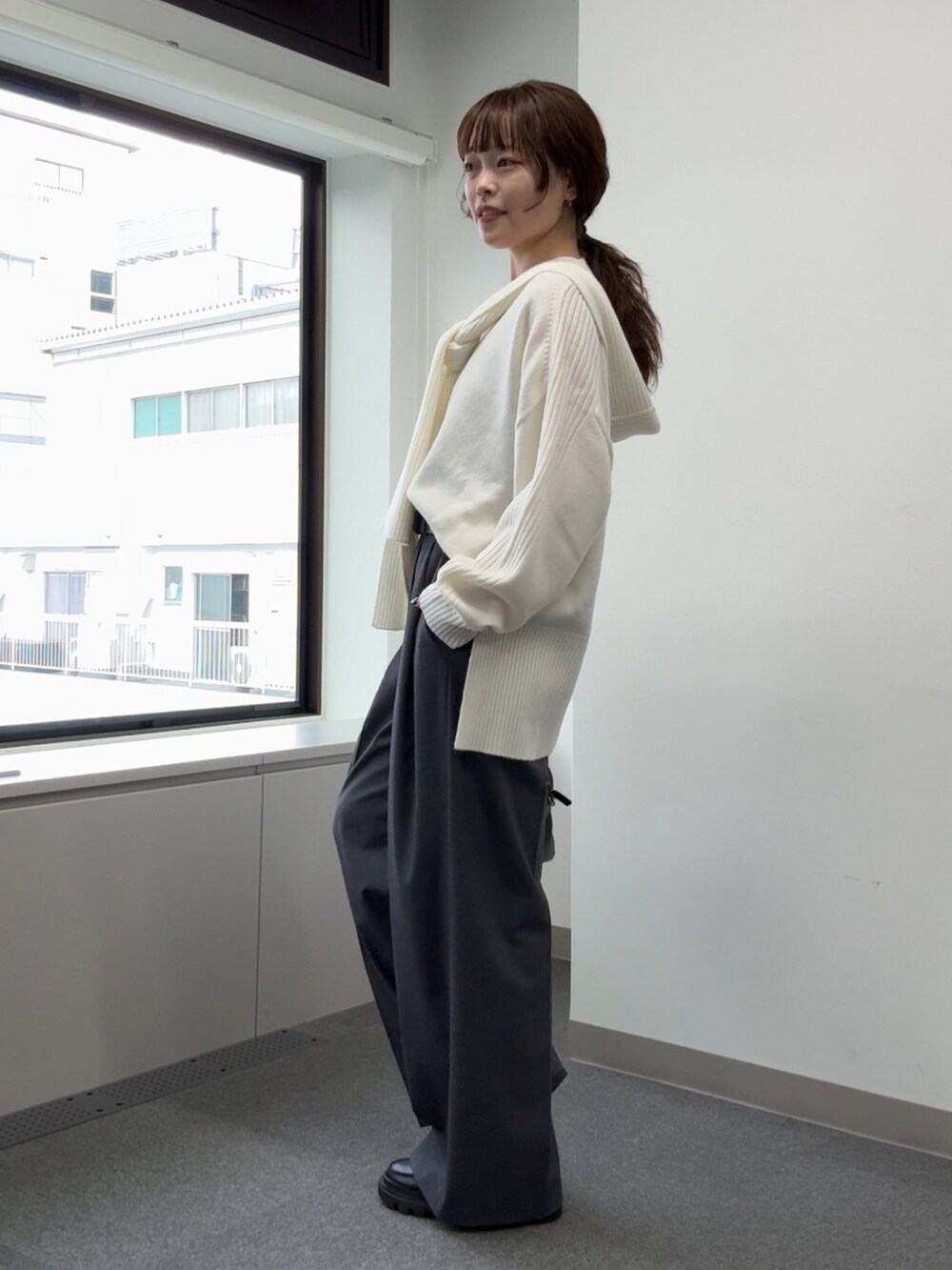 ホワイト系のニット/セーター、グレー系のその他パンツ、ブラック系のブーツを着用したレディースの秋コーディネートの5枚目の写真