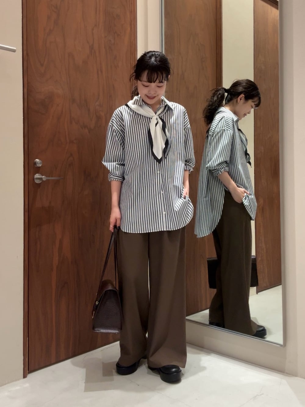 ブルー系のシャツ/ブラウス、ブラック系のその他パンツ、ブラック系のブーツを着用したレディースの冬コーディネートの6枚目の写真