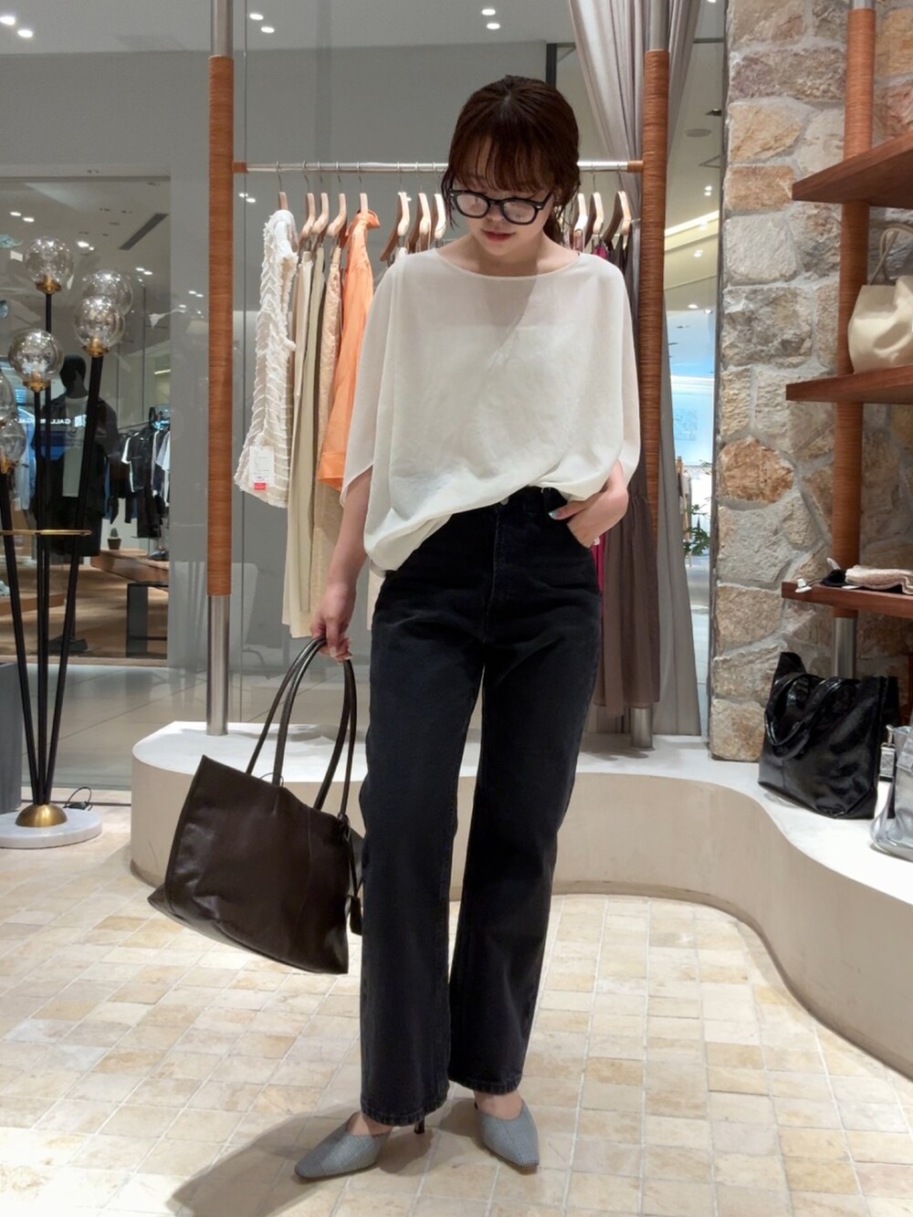 ホワイト系のシャツ/ブラウス、ブラック系のデニムパンツ、ブラウン系のトートバッグを着用したレディースの夏コーディネートの3枚目の写真