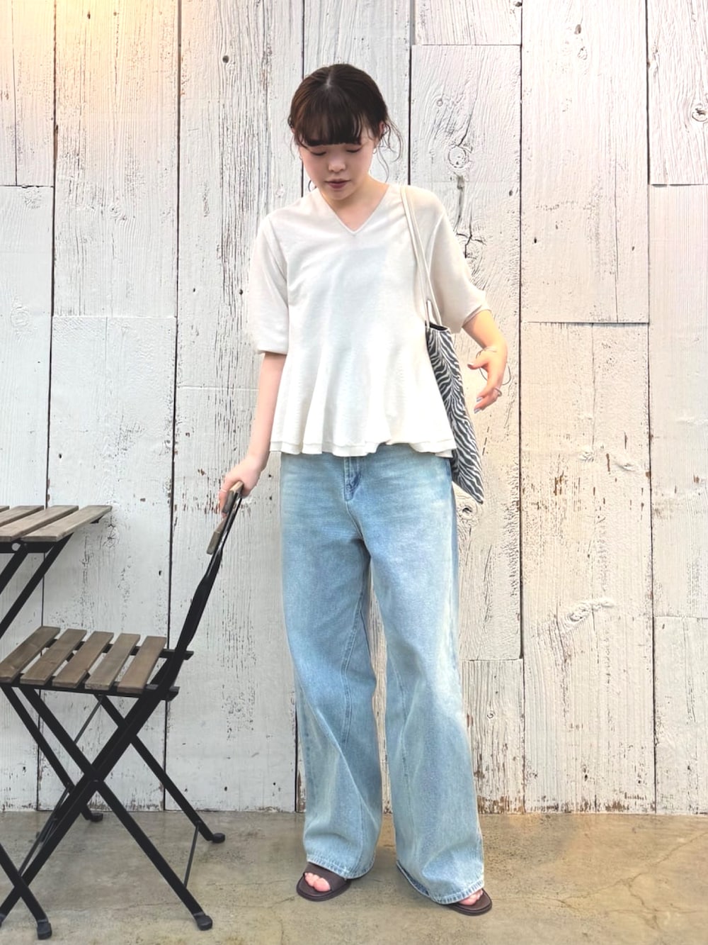 ブルー系のデニムパンツ、ブラウン系のサンダル、グレー系のニット/セーターを着用したレディースの春コーディネートの3枚目の写真