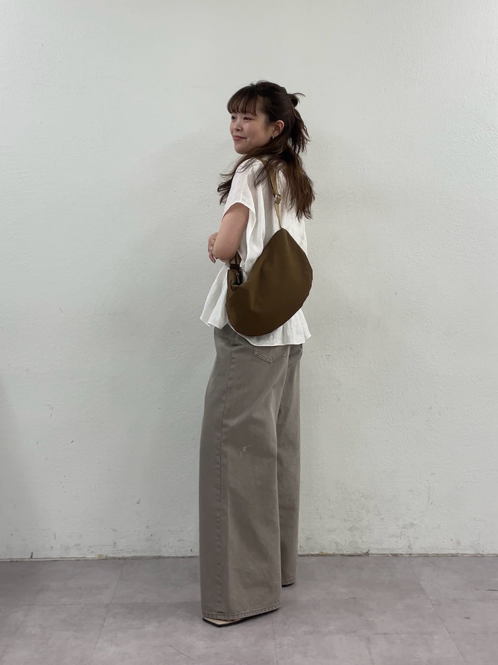 ホワイト系のシャツ/ブラウス、ブラウン系のデニムパンツ、イエロー系のショルダーバッグを着用したレディースの春コーディネートの2枚目の写真