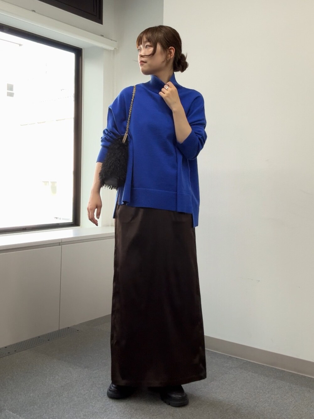 ブルー系のニット/セーター、ブラック系のショルダーバッグ、ブラウン系のスカートを着用したレディースの秋コーディネートの8枚目の写真
