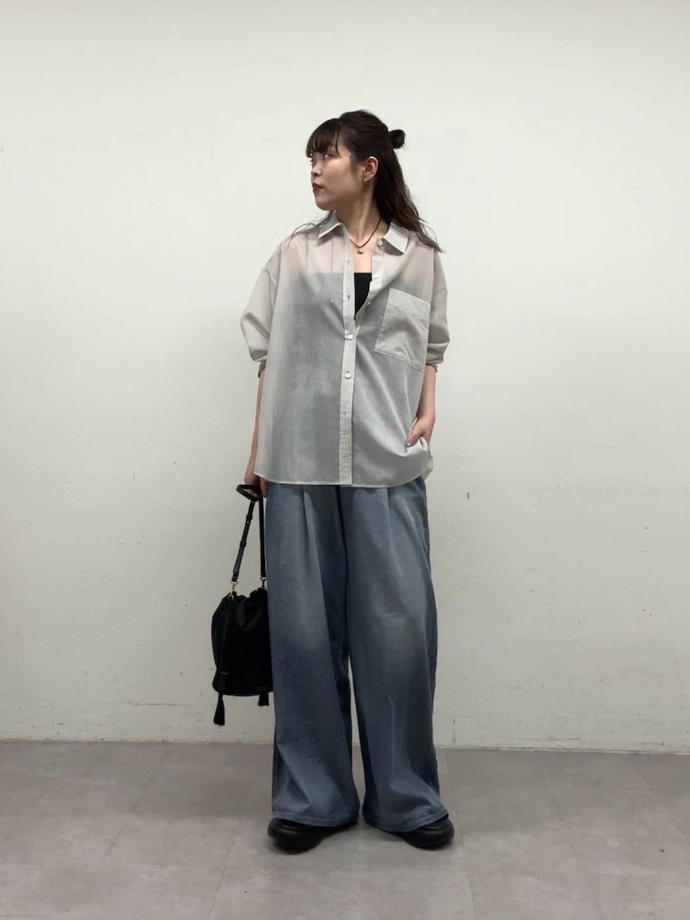 ブラック系のトートバッグ、ブルー系のその他パンツ、グレー系のシャツ/ブラウスを着用したレディースの春コーディネートの3枚目の写真