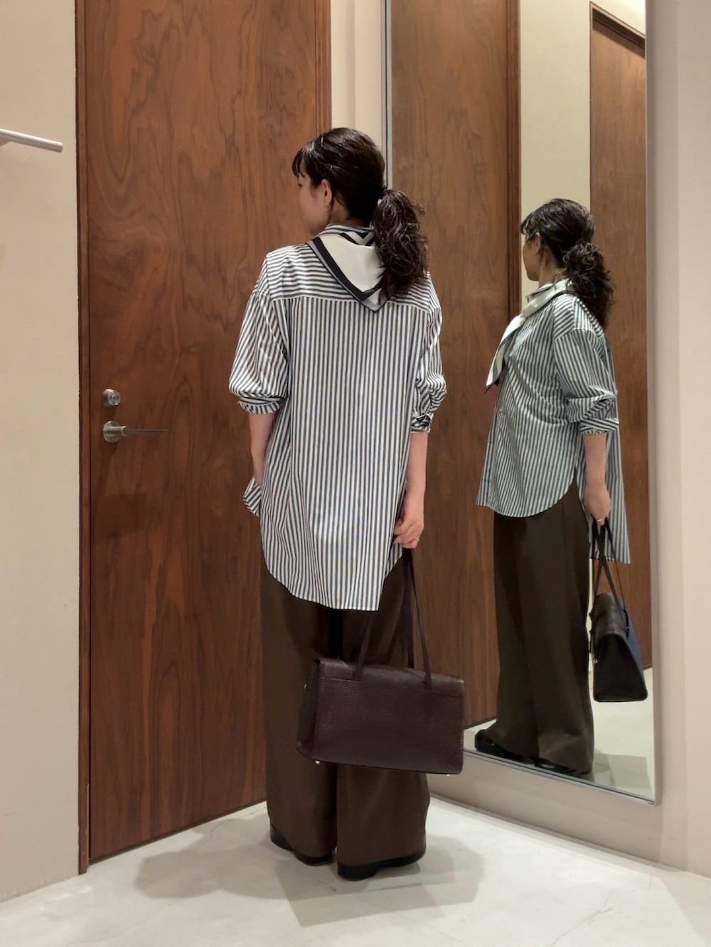 ブルー系のシャツ/ブラウス、ブラック系のその他パンツ、ブラック系のブーツを着用したレディースの冬コーディネートの5枚目の写真