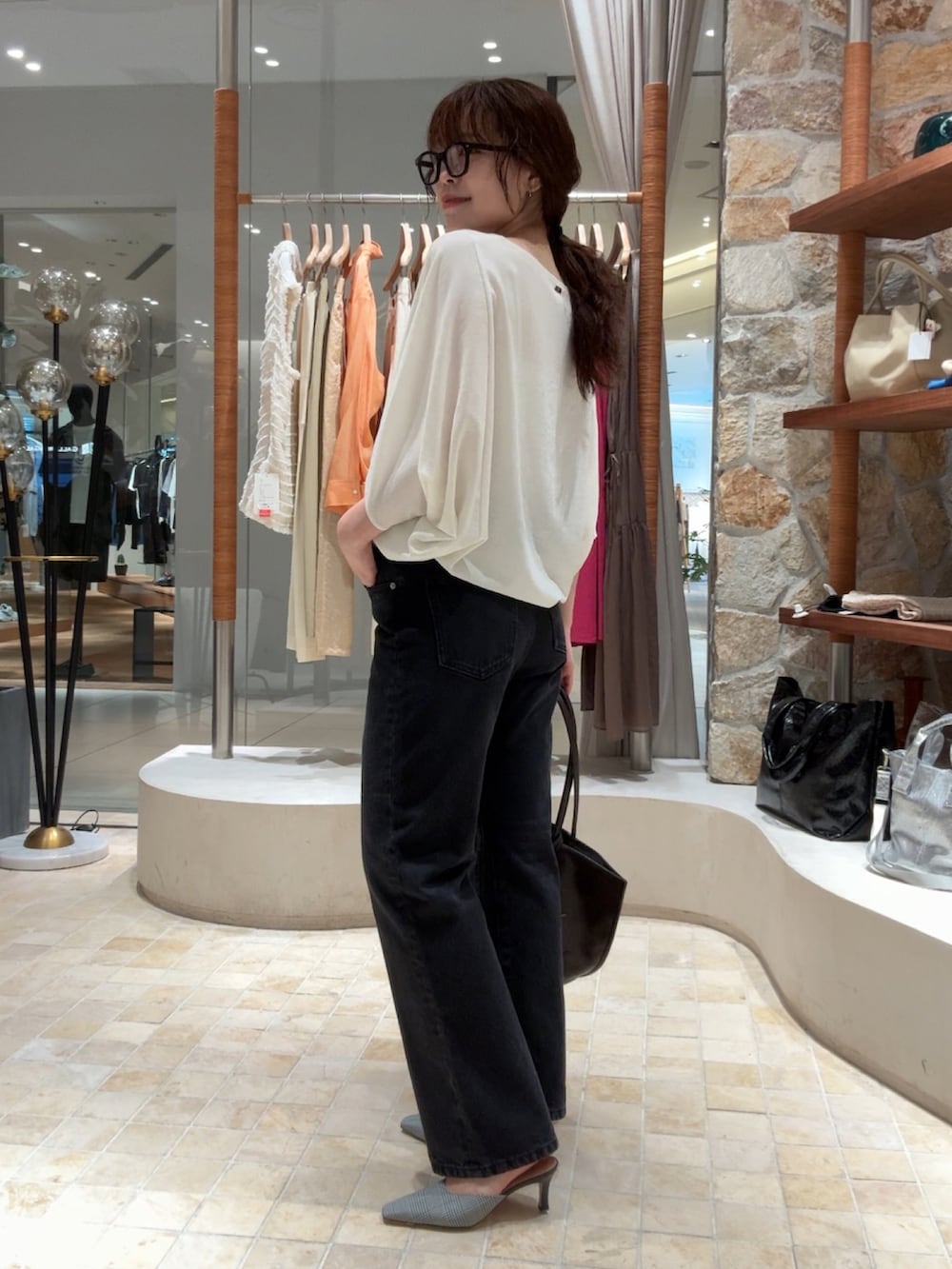 ホワイト系のシャツ/ブラウス、ブラック系のデニムパンツ、ブラウン系のトートバッグを着用したレディースの夏コーディネートの2枚目の写真