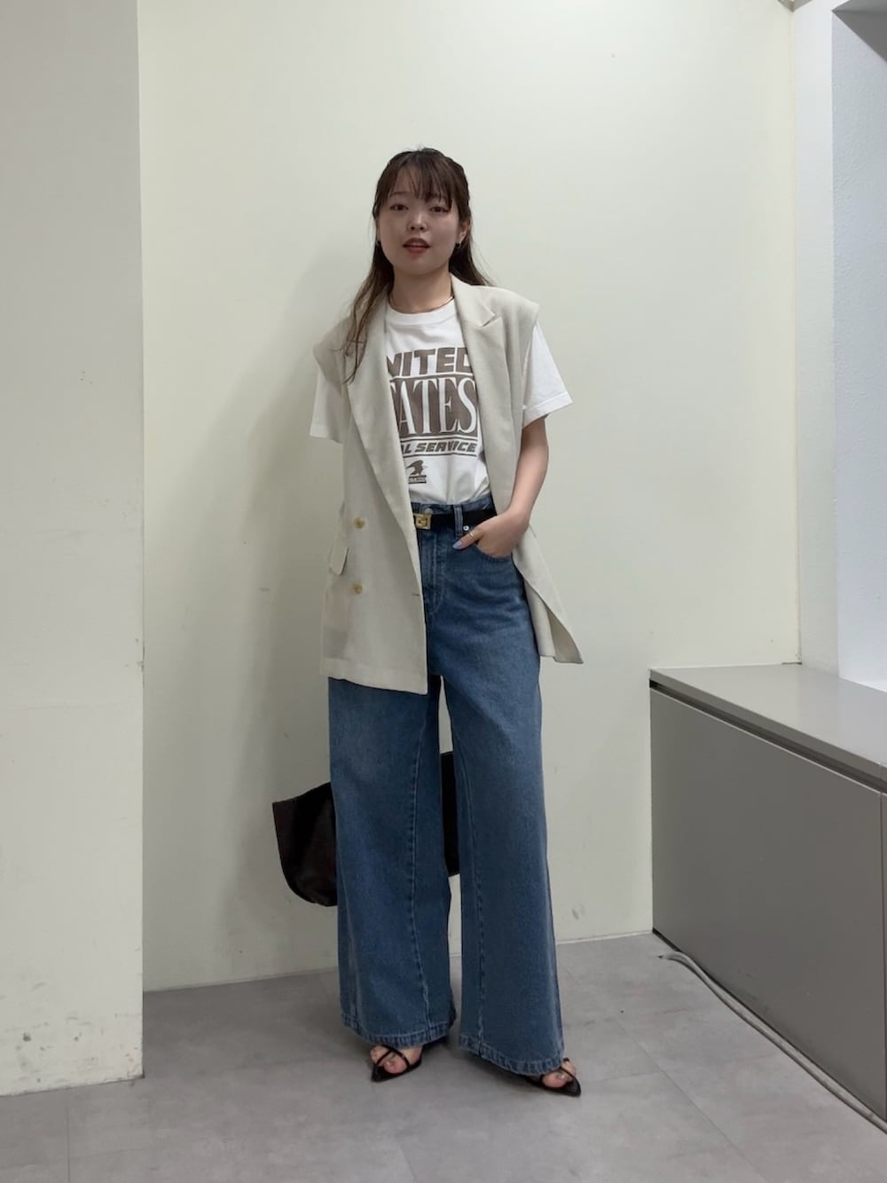 ベージュ系のベスト、ホワイト系のTシャツ/カットソー、ブラック系のサンダルを着用したレディースの春コーディネートの4枚目の写真